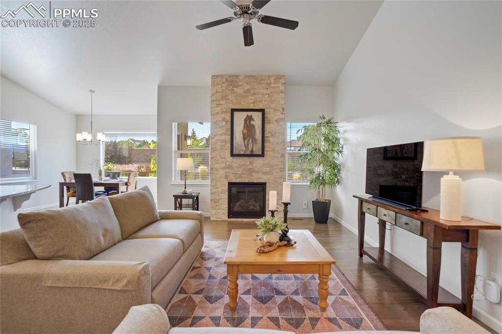Image 6 of 50: Vaulted, window-wrapped great room with stone fireplace