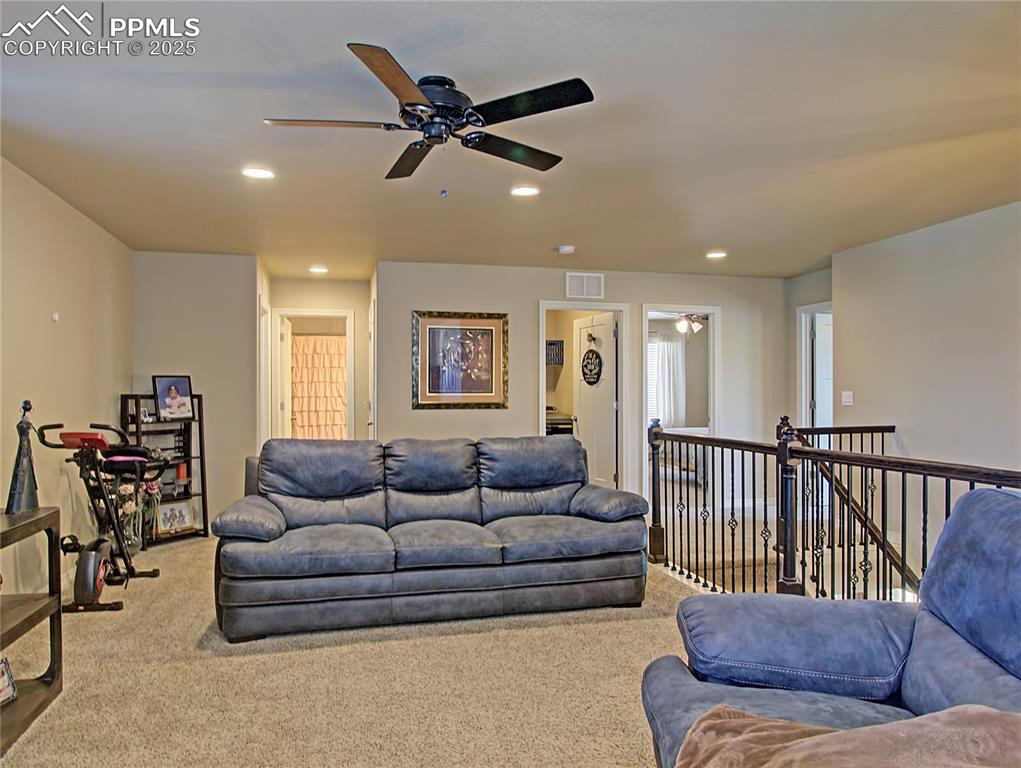 Image 18 of 30: Carpeted living room featuring a ceiling fan and recessed lighting