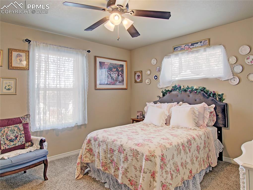 Image 19 of 30: Carpeted bedroom with a ceiling fan and baseboards