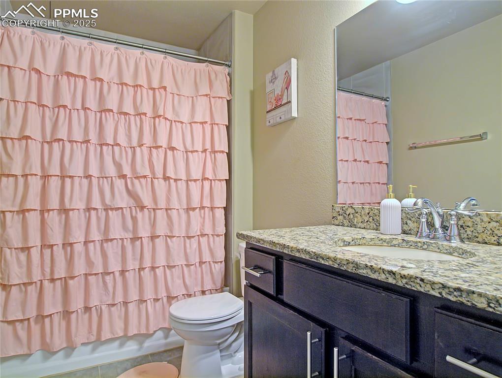 Image 20 of 30: Full bath featuring vanity, shower / bath combo with shower curtain, a text