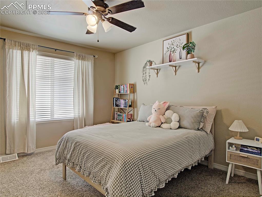 Image 22 of 30: Carpeted bedroom with ceiling fan and a textured ceiling