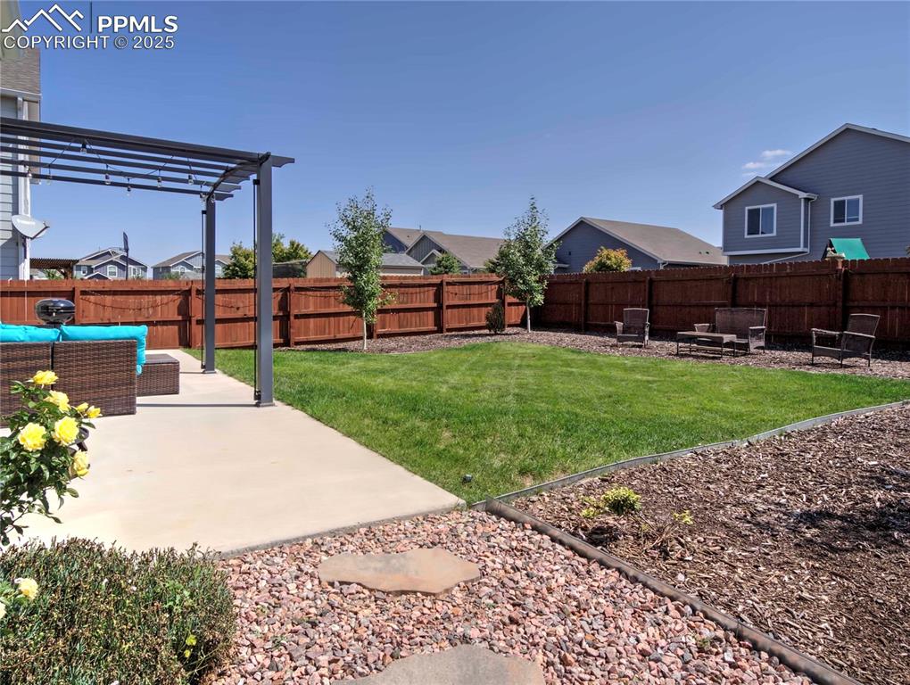 Image 30 of 30: Fenced backyard featuring a patio area, a residential view, outdoor lounge
