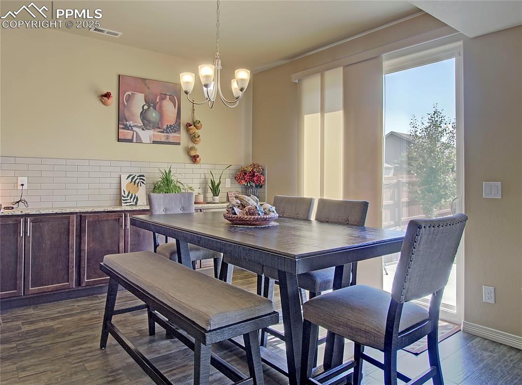 Image 8 of 30: Dining room featuring dark wood-type flooring and a chandelier