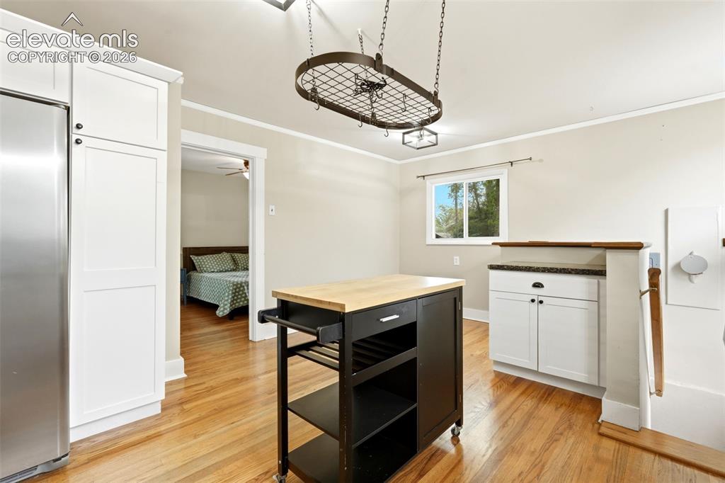 Image 11 of 40: Hardwood flooring throughout the space, complemented by white shaker-style