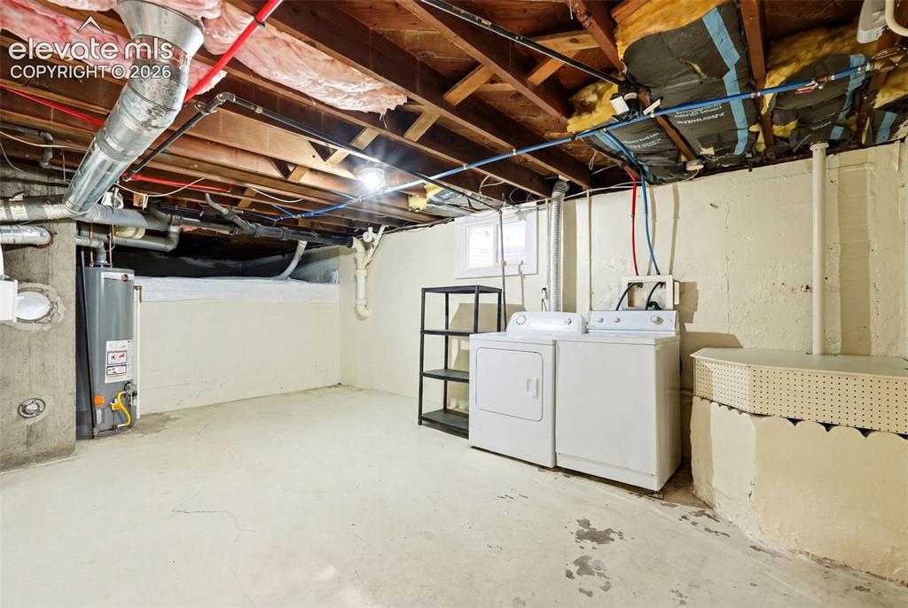 Image 20 of 40: Utility area featuring a water heater, washer, and dryer