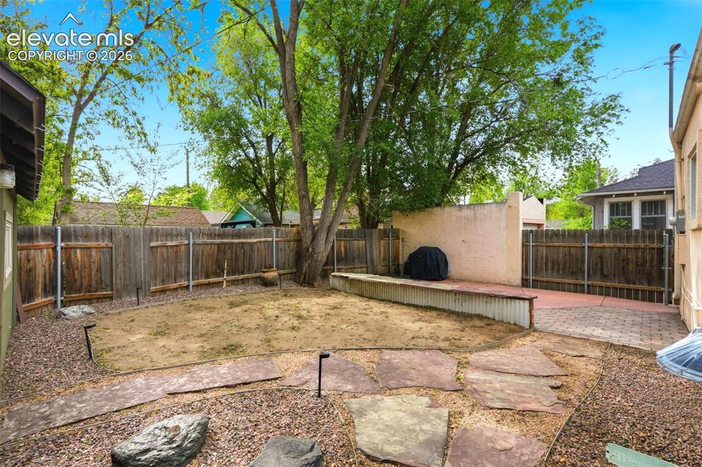 Image 30 of 40: Private backyard featuring a paver patio area, stone stepping pads, and per