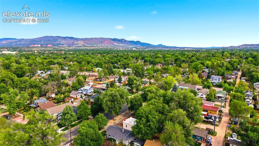 Image 37 of 40: Expansive residential district featuring mature tree canopy and distant mou