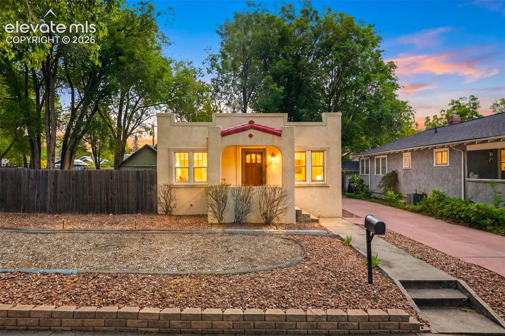 Image 4 of 40: Southwestern architectural style with a covered entry, arched details, and