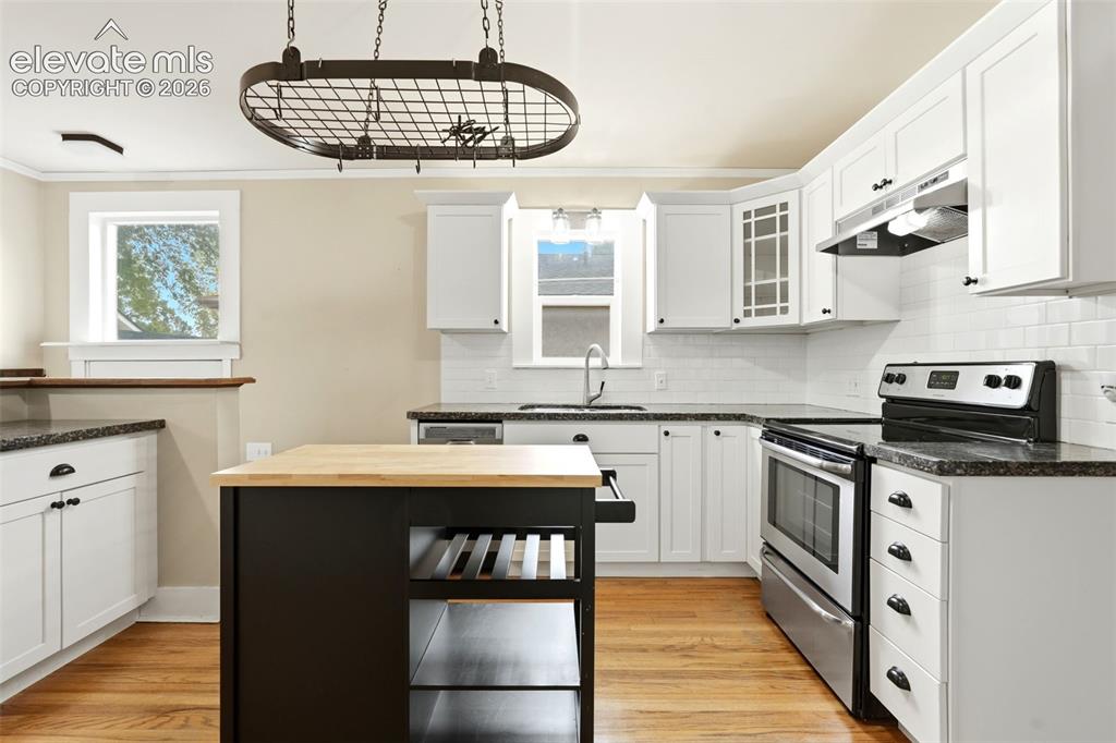 Image 8 of 40: Bright kitchen featuring white shaker cabinetry, stainless steel appliances