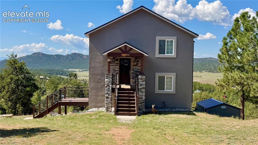 Image 3 of 49: Two-story exterior with stucco finish, stone accents, and a covered entry