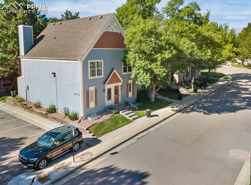 Image 20 of 27: View of front facade featuring roof with shingles and a chimney