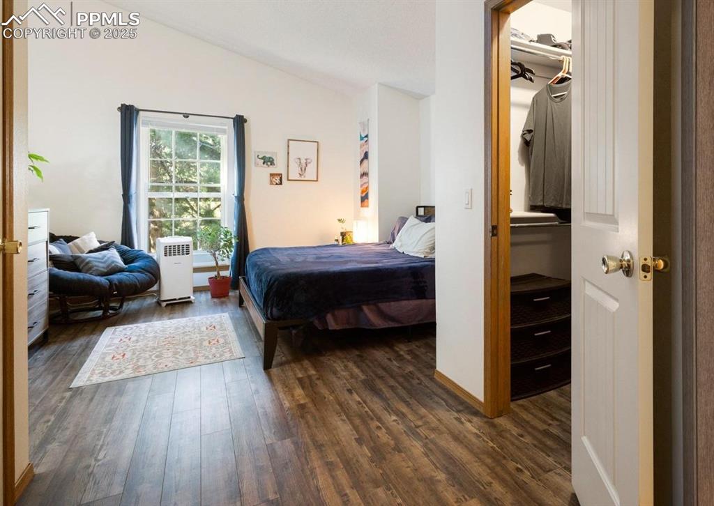 Image 6 of 27: Bedroom with dark wood-type flooring and lofted ceiling