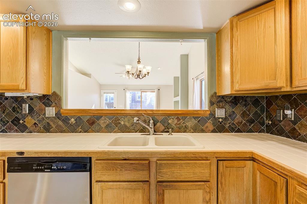 Image 18 of 50: Recessed lighting, wood cabinetry, tile backsplash, laminate countertops, a