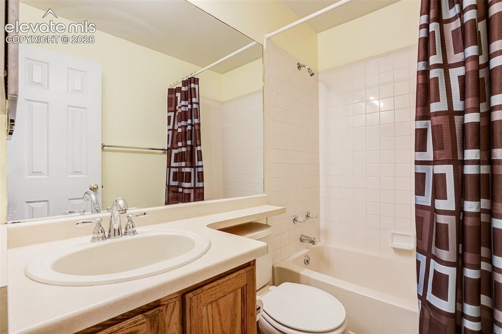 Image 33 of 50: Bathroom featuring a wood-finish vanity with an integrated sink and chrome