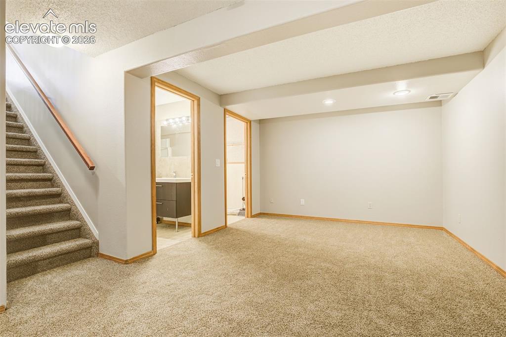 Image 38 of 50: Carpeted flooring, recessed lighting, wood trim, and a built-in vanity with