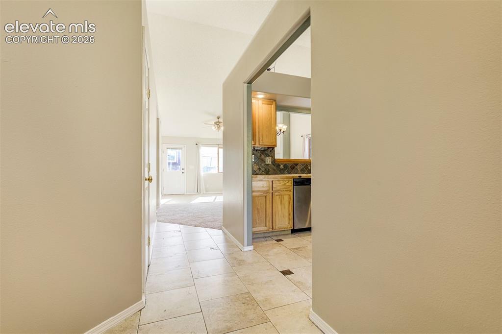 Image 4 of 50: Travertine-style floor tile, recessed entry, vaulted ceiling, wood-finish c