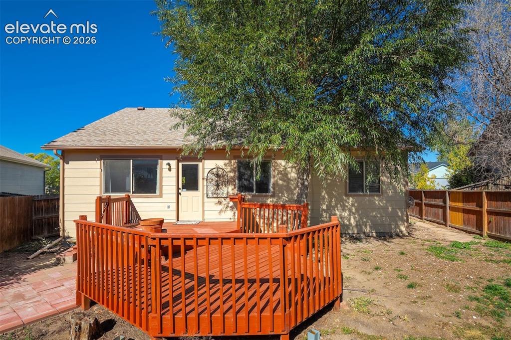 Image 47 of 50: Expansive backyard featuring a multi-level wood deck, privacy fencing, and