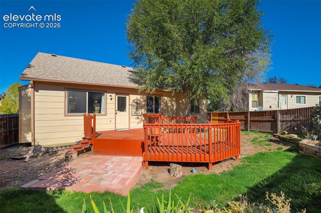 Image 48 of 50: Expansive backyard featuring a large wood-finish deck, a brick paver patio,