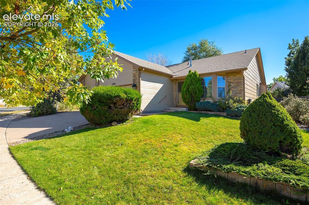 Image 49 of 50: Single-story residence featuring a two-car garage, front landscaping with m