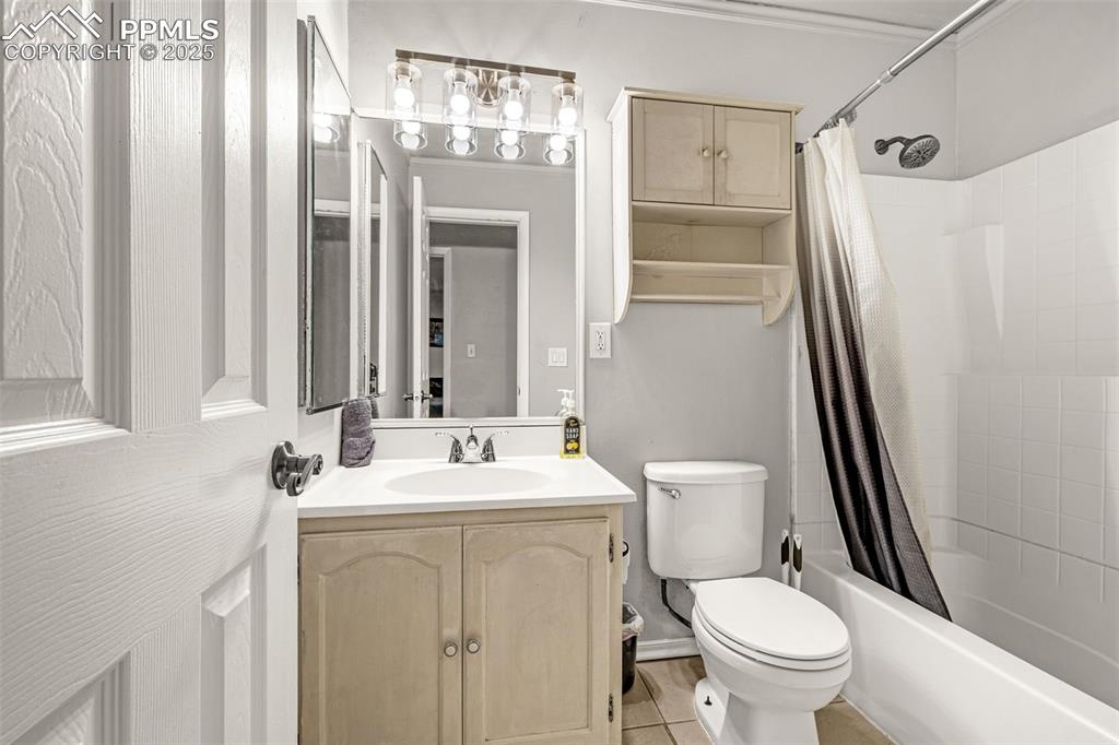 Image 11 of 22: Bathroom featuring shower / bath combination with curtain, vanity, and ligh