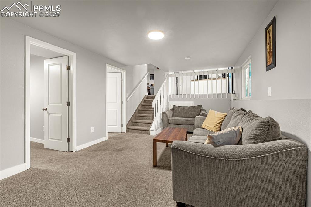 Image 15 of 22: Living room featuring carpet floors and stairway