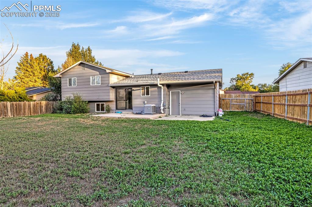 Image 21 of 22: Back of property with a fenced backyard, a patio, and roof with shingles
