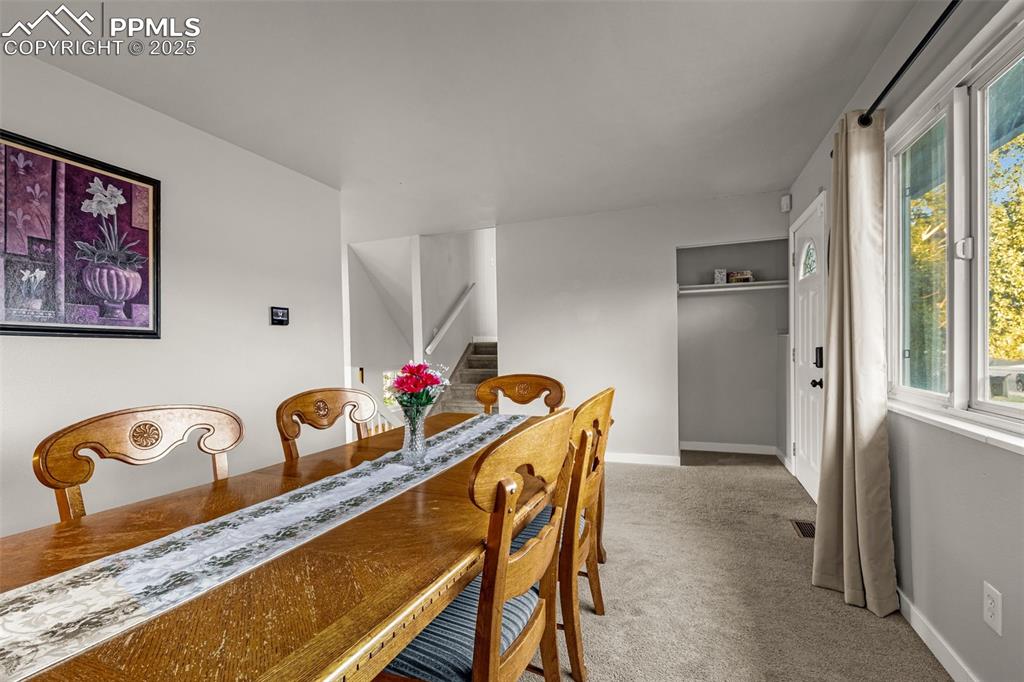 Image 6 of 22: Dining area with light carpet and stairs
