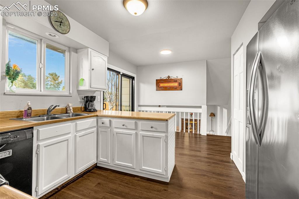 Image 9 of 22: Kitchen featuring a peninsula, stainless steel fridge, black dishwasher, wh