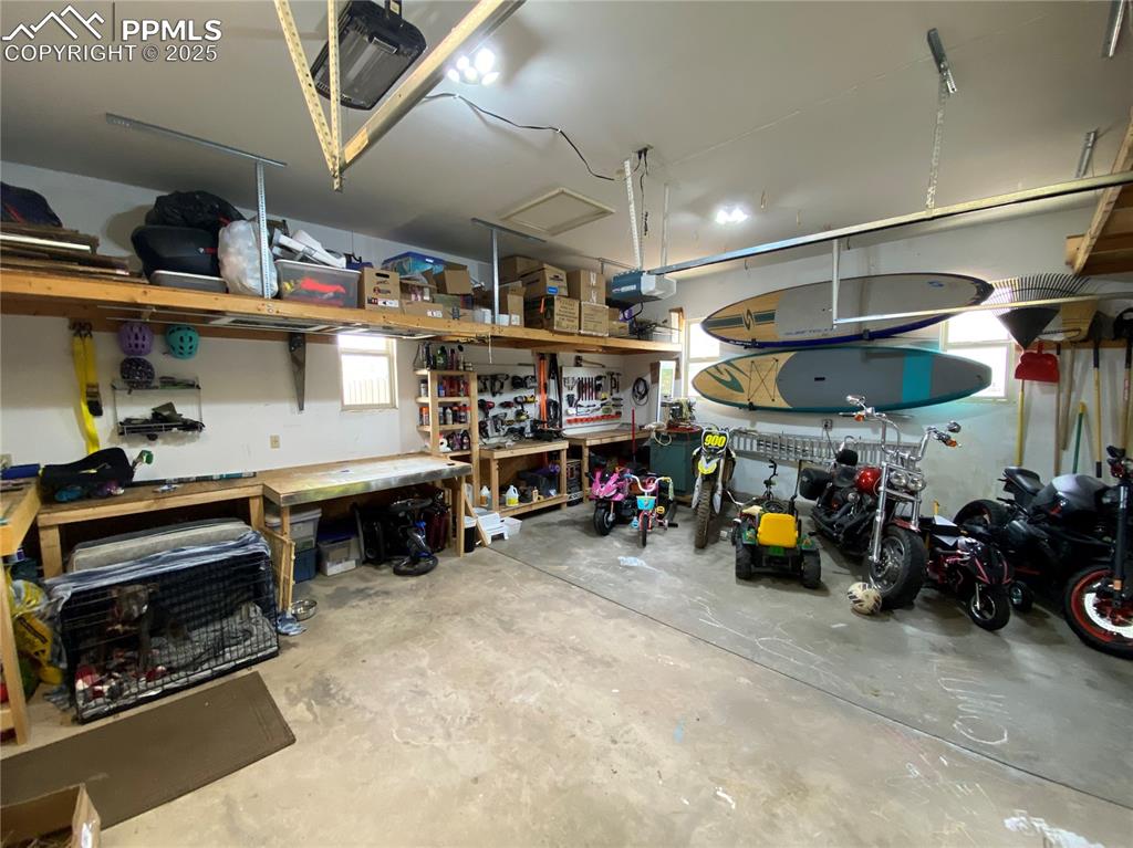 Image 31 of 48: With built-in workbenches & shelving, this is more than a garage for cars