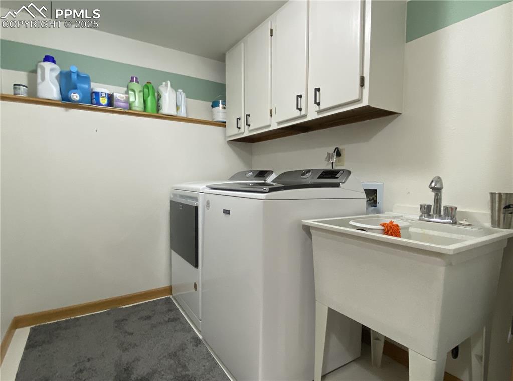 Image 34 of 48: The laundry room is tucked away behind the stairs