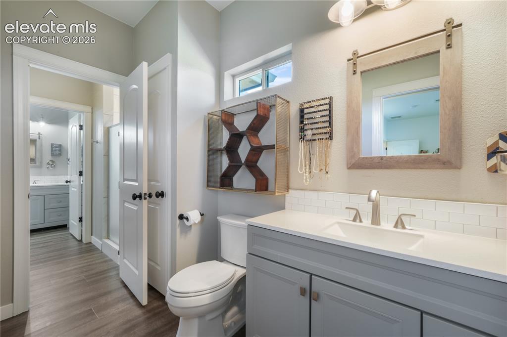 Image 34 of 50: Main level secondary suite bathroom with walk in shower and built in shelvi