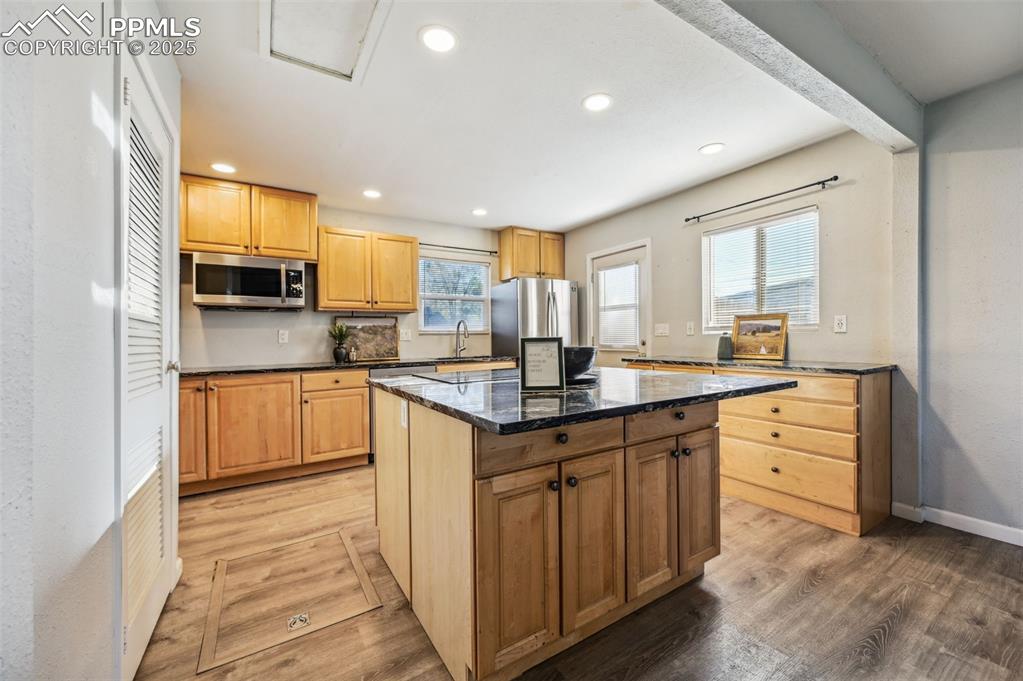 Image 12 of 28: Kitchen with appliances with stainless steel finishes, light wood finished 