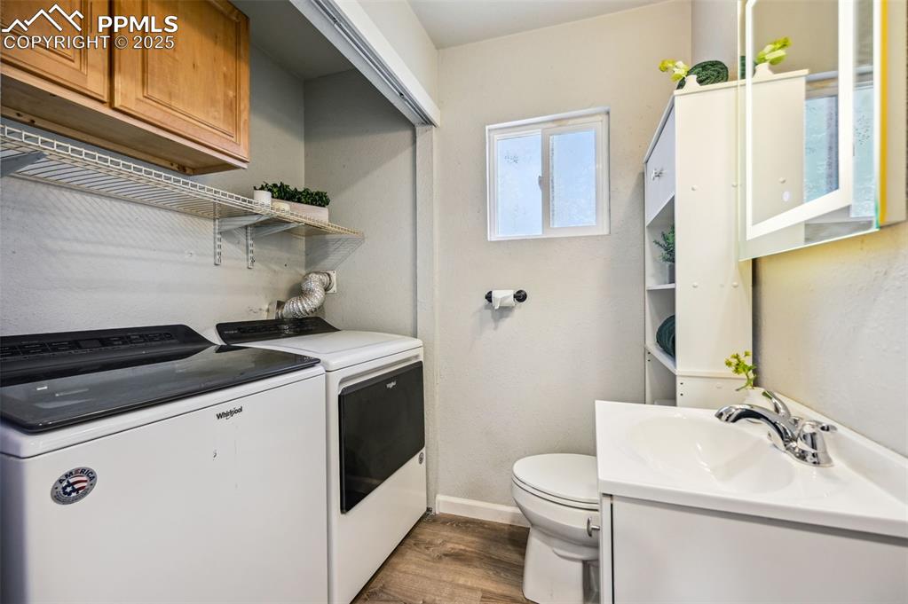 Image 16 of 28: Laundry room with washing machine and dryer, dark wood-type flooring, and b