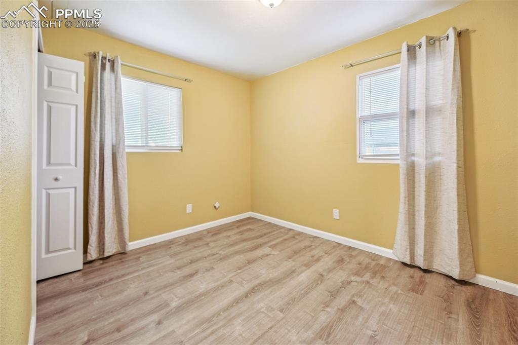 Image 24 of 28: Unfurnished bedroom with wood finished floors and baseboards