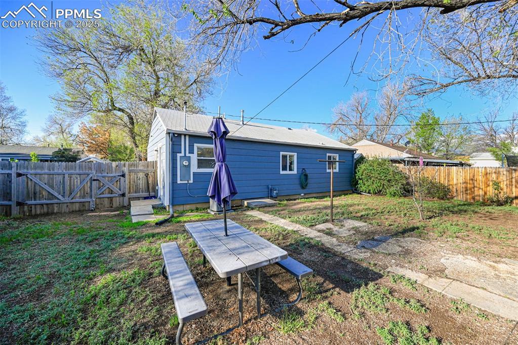 Image 28 of 28: Back of property featuring a fenced backyard and a gate