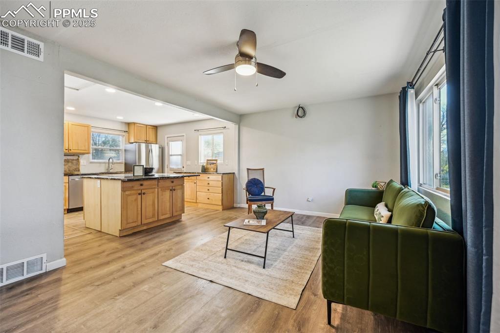 Image 6 of 28: Living room featuring baseboards, light wood-type flooring, a ceiling fan, 