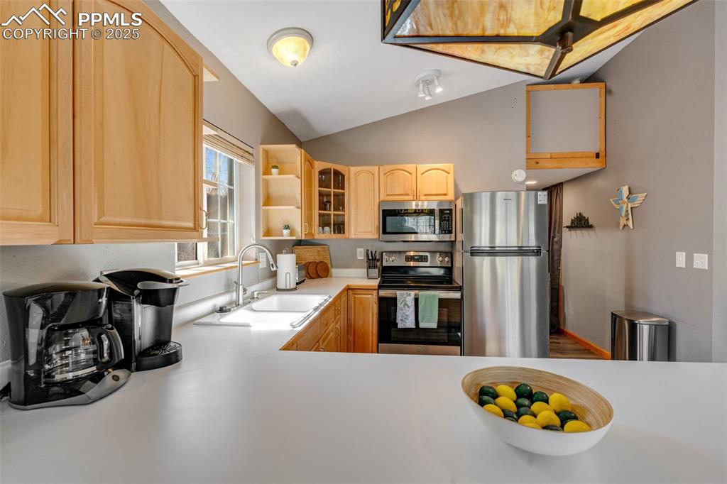 Image 12 of 34: Kitchen featuring appliances with stainless steel finishes, light counterto