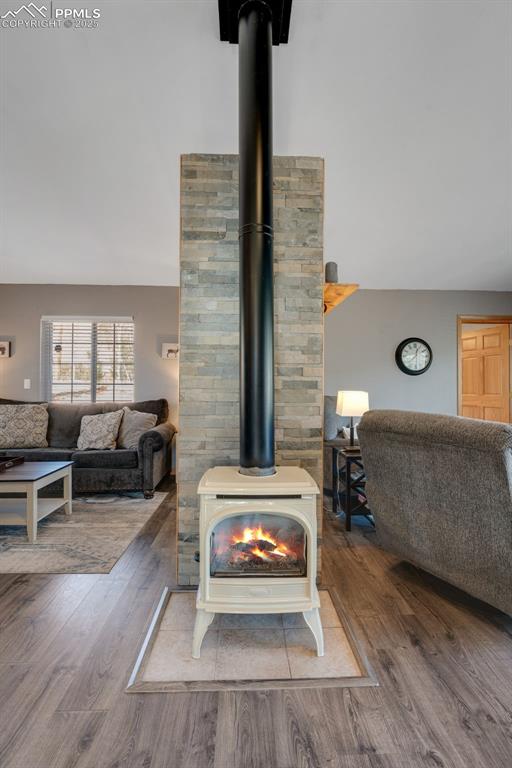 Image 22 of 34: Detailed view of a wood stove and wood finished floors