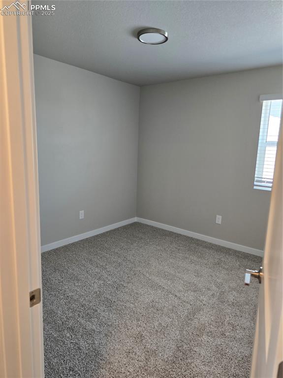 Image 3 of 15: Carpeted spare room featuring baseboards and a textured ceiling