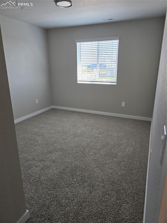 Image 6 of 15: Spare room featuring carpet flooring and a textured ceiling