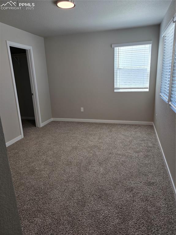 Image 7 of 15: Carpeted spare room with a textured ceiling and baseboards