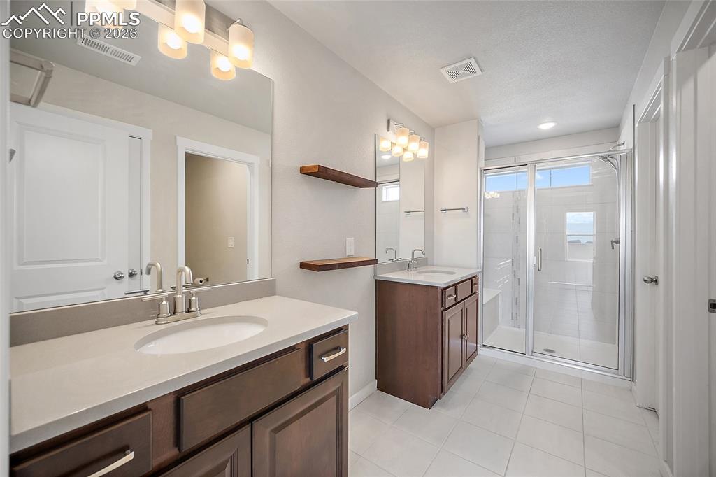 Image 20 of 41: Primary bathroom with double vanity and spacious walkin shower