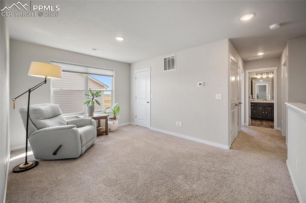 Image 24 of 41: Loft flex space with view to third bedroom entry, full guest bath, and laun