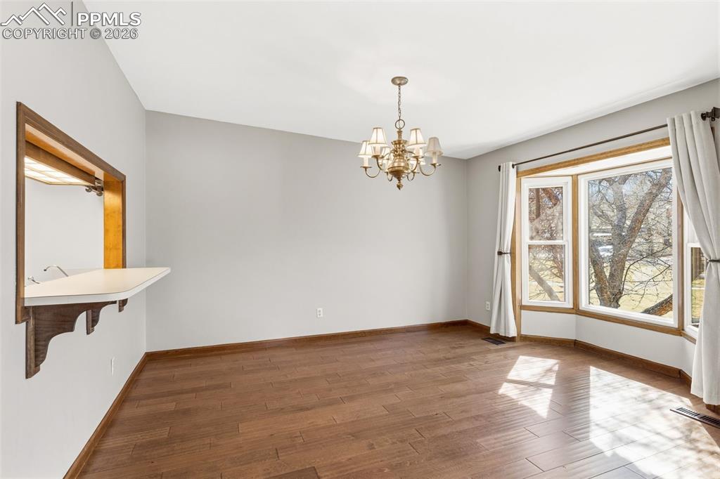 Image 16 of 35: Hardwood floor and bay window in the dining room