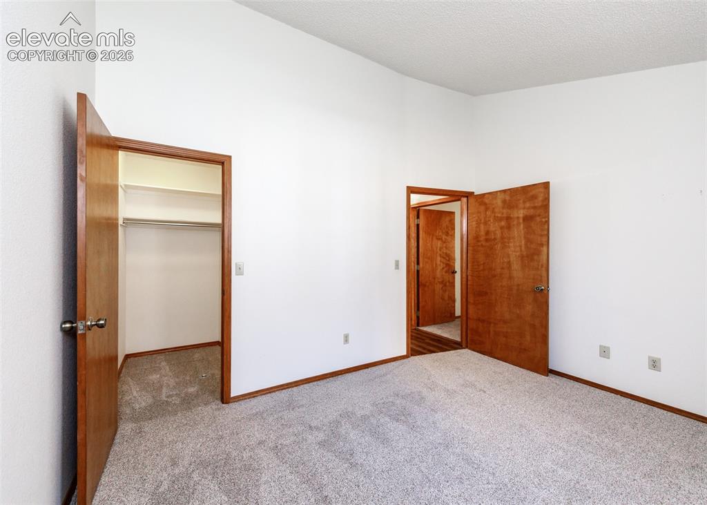 Image 17 of 22: Wall-to-wall carpeting, wood-finish doors, and white walls