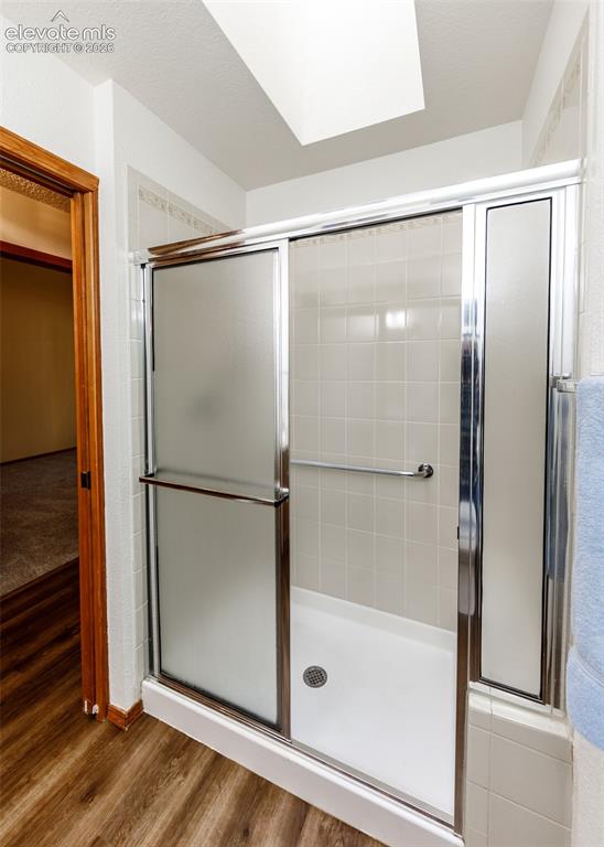 Image 19 of 22: Shower with sliding frosted glass doors, white tile surround, and grab bar