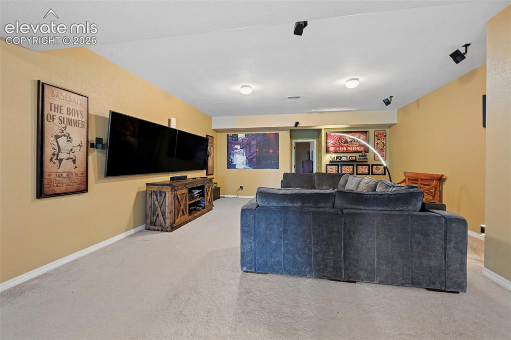 Image 10 of 43: Recessed lighting, track lighting, light-toned carpeting, and a built-in me