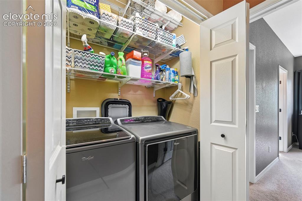 Image 28 of 43: Dedicated laundry area featuring modern appliances and wire shelving