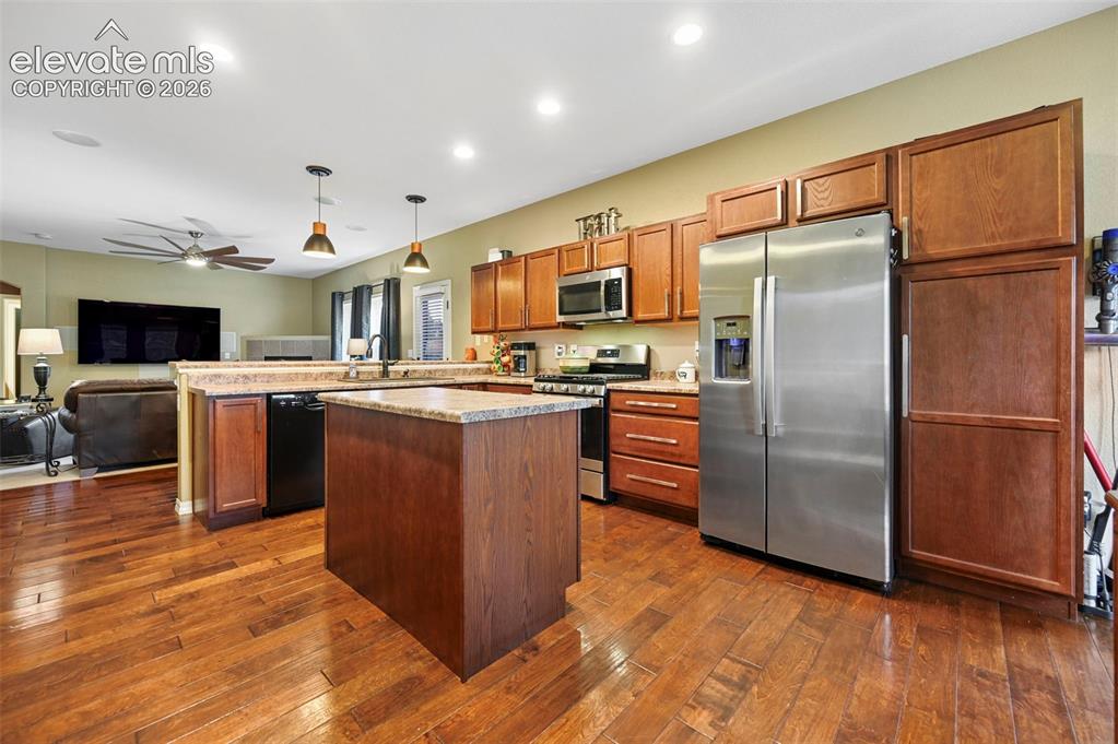Image 3 of 43: Kitchen featuring wood-finish flooring, wood cabinetry, stainless steel app