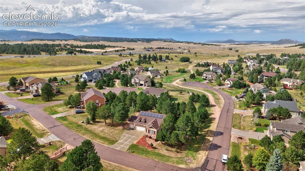 Image 34 of 43: Residential properties with varied architectural styles, mature trees, and 